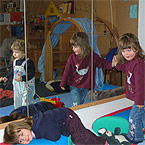 Drei spielende Kinder vor Spiegel