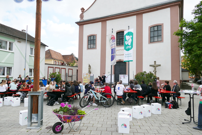 Platz mit vielen Jugendlichen beim Jugendforum 2022 vor der Kirche in Jöhlingen