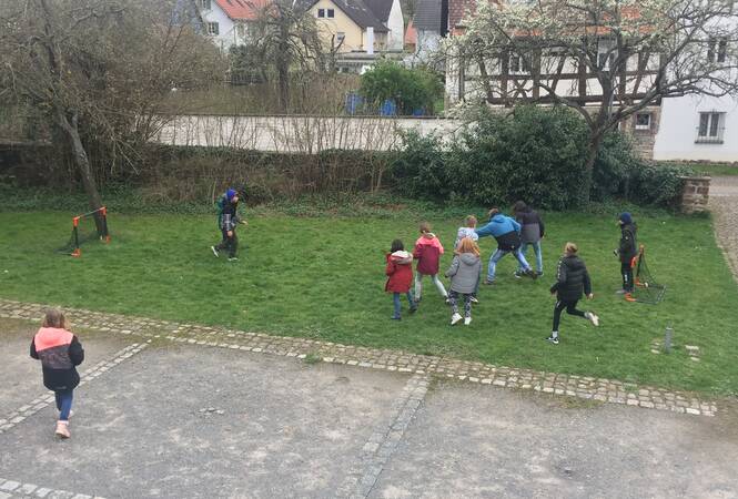 Kinder spielen auf einer Wiese Fußball