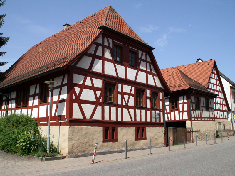 Altes Fachwerkhaus an der Straße, klarerer Himmel.