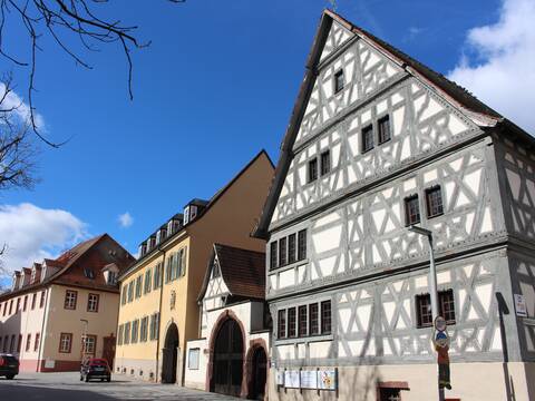 Altes Fachwerkhaus mit kleinem  Torbogen, blauer Himmel.
