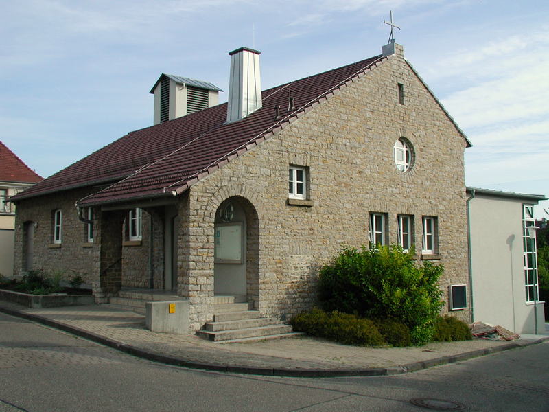 graue Steinkirche, im Hintergrund hellblauer Himmel.