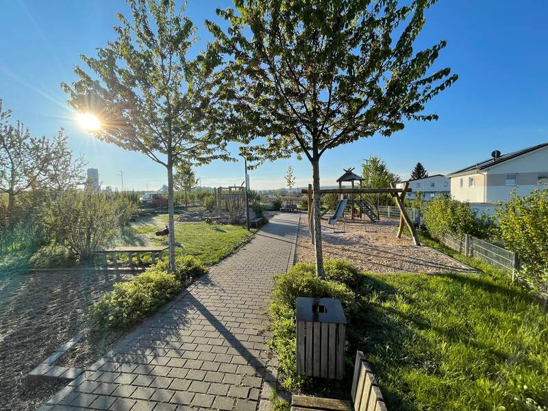 Bild des Spielplatzes im Wohngebiet Bäderäcker mit verschiedenen Spielgeräten unter blauem Himmel