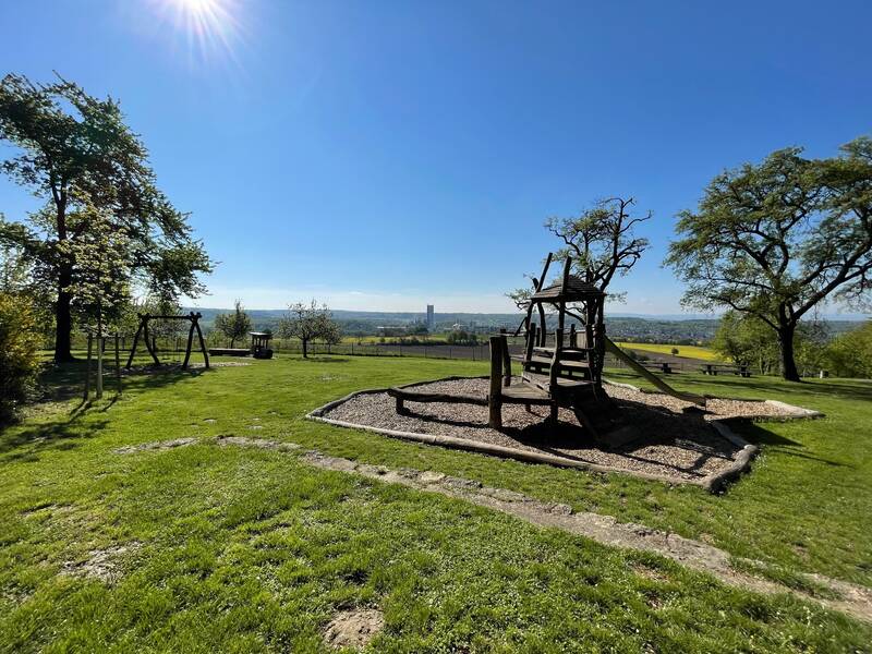 Blick auf das Spielgerät am Grillplatz Fraueneich. Im Hintergrund ist der Ortsteil Wössingen zu sehen.