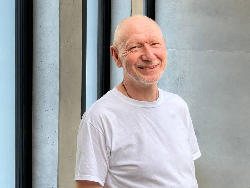 Portrait von Christian Kliewer im weißen T-Shirt im Treppenhaus