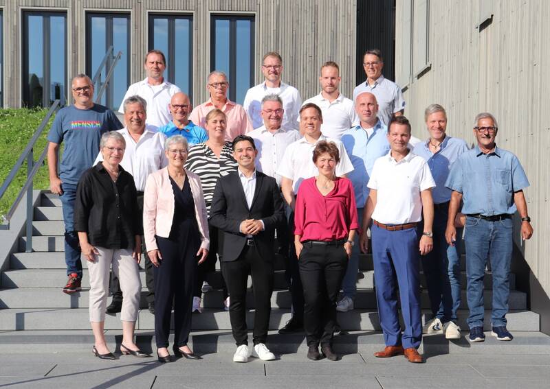 Gruppenbild des Gemeinderats auf der Außentreppe neben dem Rathaus. Bürgermeister Özcan steht in der 1. Reihe in der Mitte, um ihn herum die Mitglieder des Gemeinderats