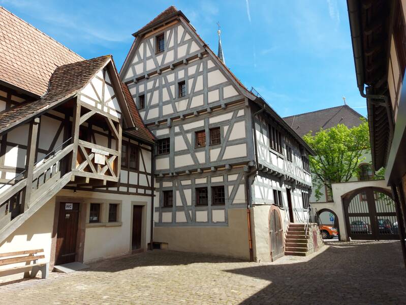 Innenhof des Speyerer Hofs mit Blick auf das Fachwerkhaus und den Treppenaufgang in das Nebengebäude.