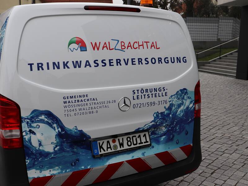 Fahrzeug der Trinkwasserversorgung in weiß mit blauen Elementen steht auf dem Rathausplatz