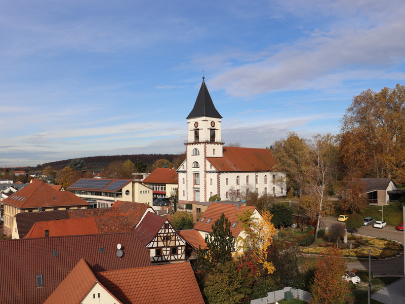 Evangelische Kirche Wössingen umgeben von Häusern.