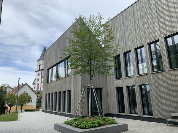 Innenhof des Rathauses. In der Mitte ein Baum. Im Hintergrund die evangelische Kirche