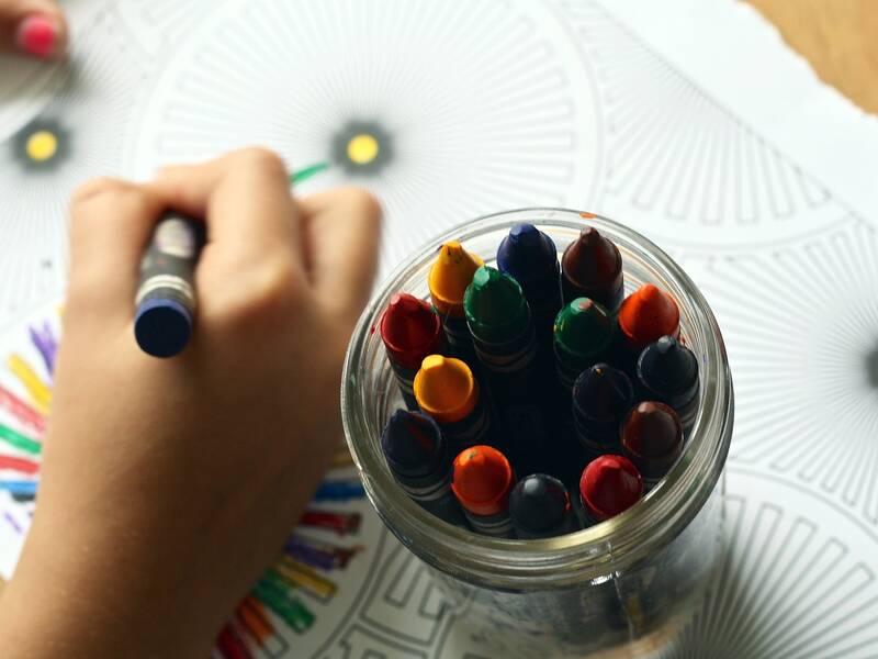 Kind malt mit Buntstiften ein BIld