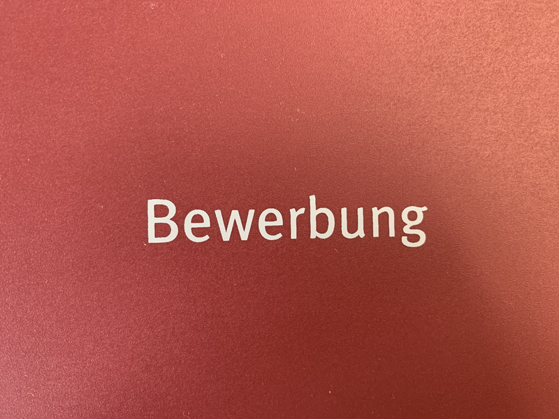 Schriftzug Bewerbung auf roten Hintergrund