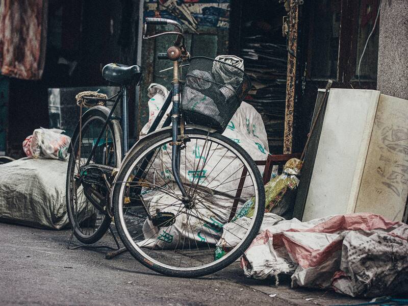 Sperrmüll auf einer Straße. Unter anderem ein Fahrrad und verchiedene Müllbeutel