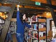 Mädchen greift in ein Bücherregal